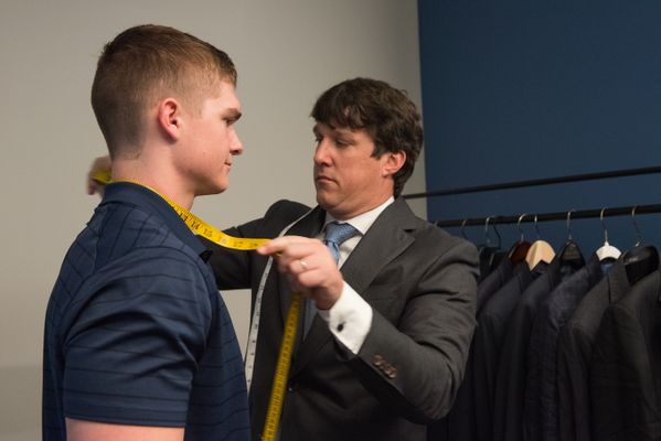 Phil from Daniel's of Morgantown measuring a business student for a suit 