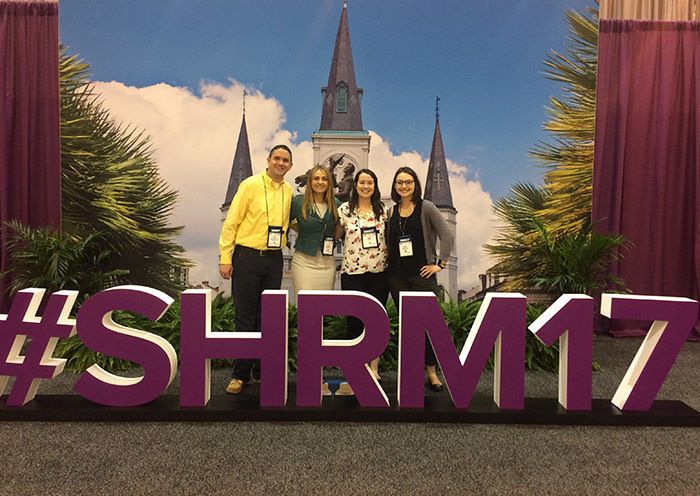 group of people standing behind a sign that says "SHRM17"