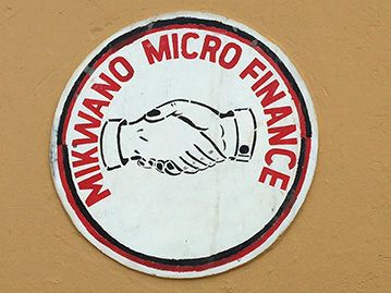 painting on a wall that says "mikwano micro finance" with hands shaking
