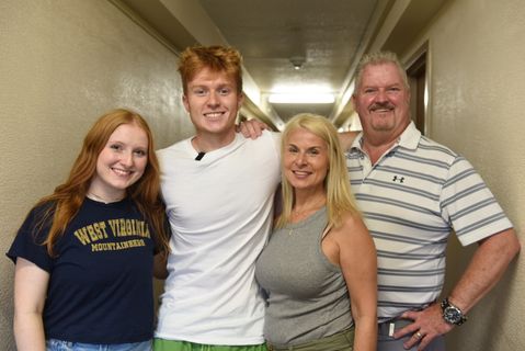 A business freshman poses for a picture with his family as he moves into the CLIMB LLC 