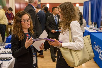 A Female Business Students Talks to an Employer at the Career Fair 