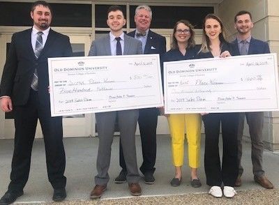 WVU students and staff holding giant checks